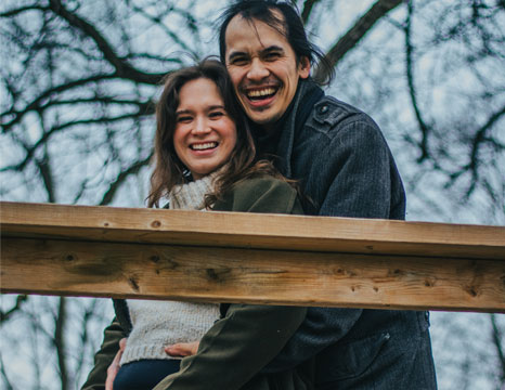 Husband and Wife posing for a prenancy announcement photoshoot.