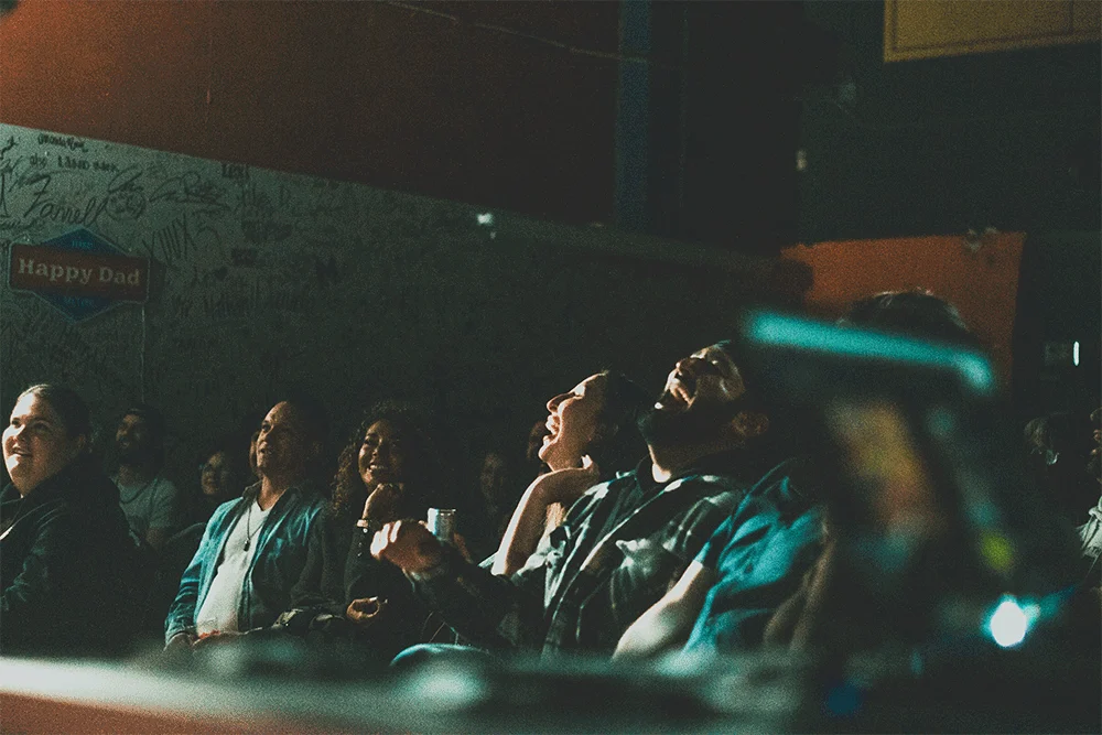 Crowd laughing at a comedy show.